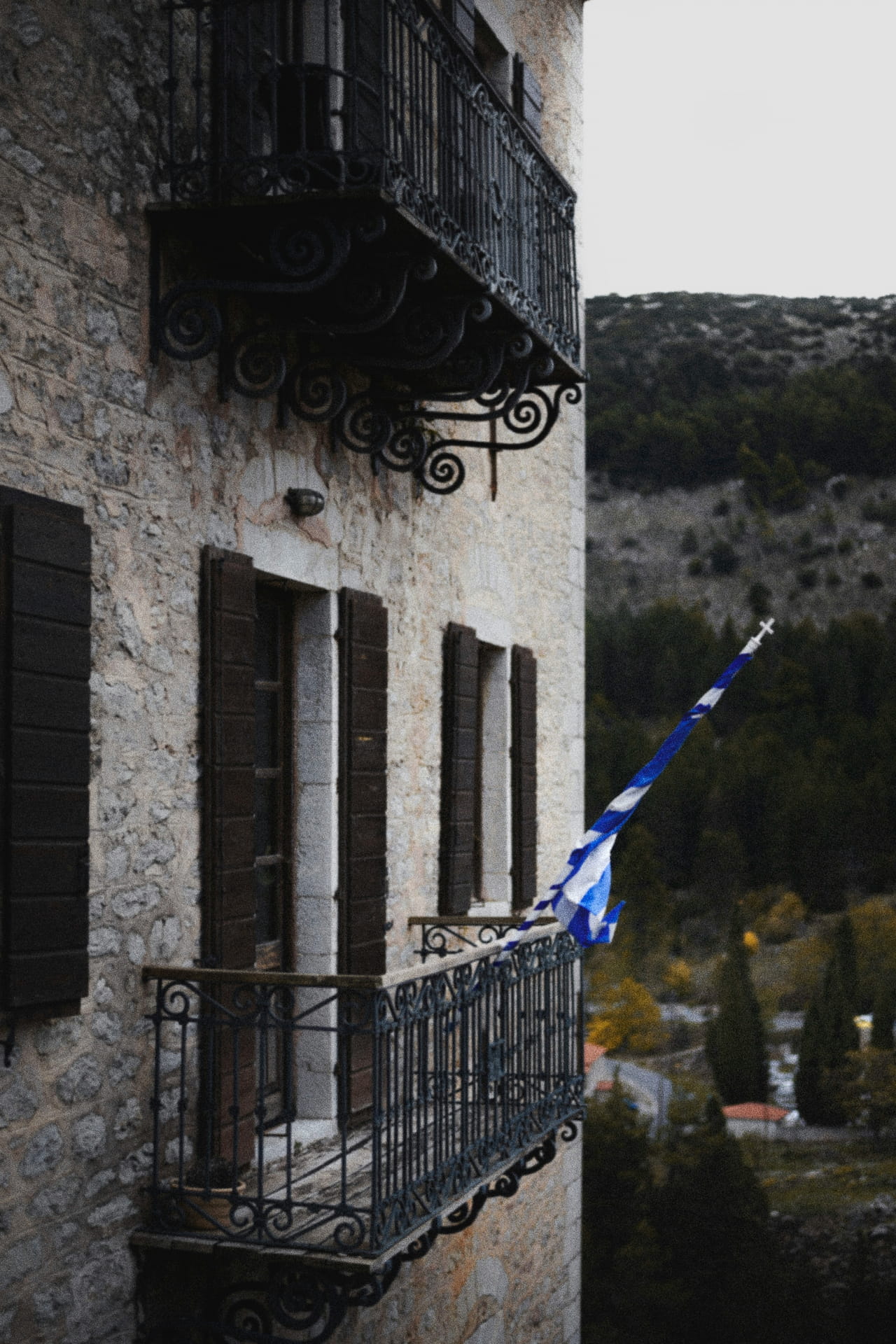 Old house made of stone with a greek flag